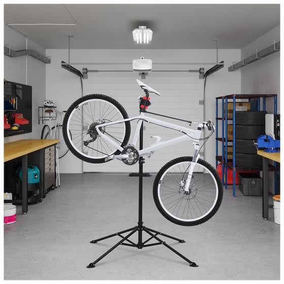 De fiets reparatie standaard in de garage met fiets