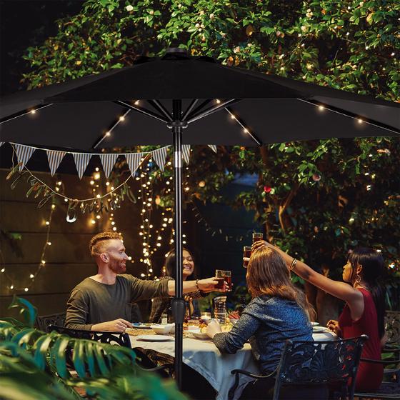 Parasol with solar lighting with lighting on in the garden