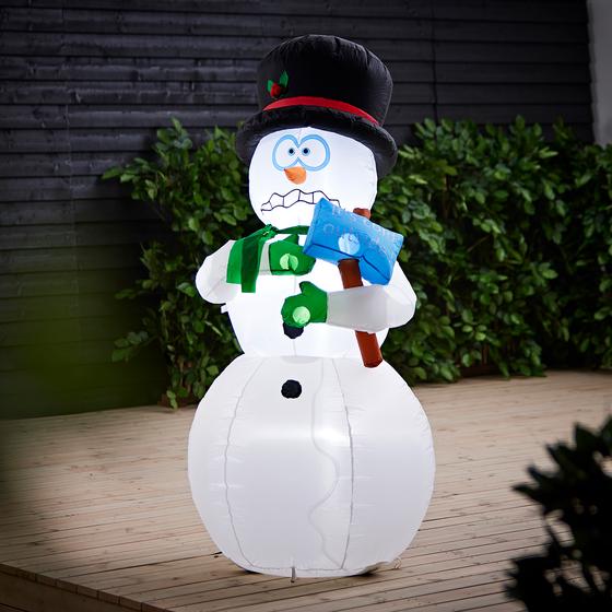 Inflatable snowman with light standing in garden