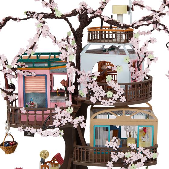 Détails de la cabane miniature en carton dans un cerisier en fleurs