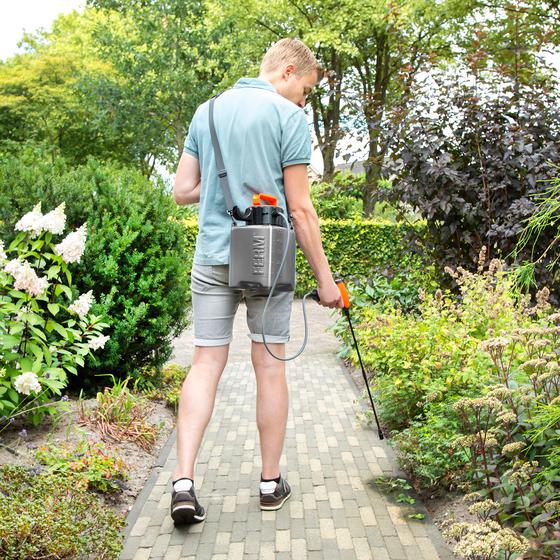 Man die de FERM sproeier en drukspuit gebruikt in de tuin