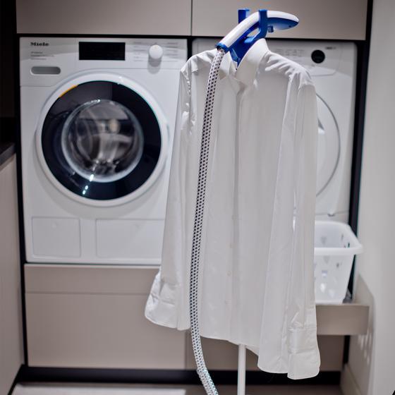 Clothing and fabric steamer with a shirt on the hanger