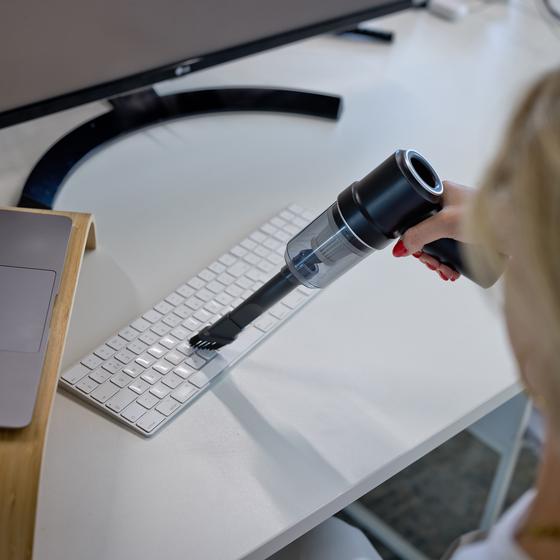 Aspirateur à main en train de nettoyer un clavier