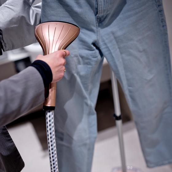 Défroisseur vapeur en cours d'utilisation sur un pantalon