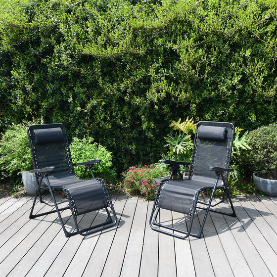 Deux chaises longues réglables installées dehors sur une terrasse au soleil