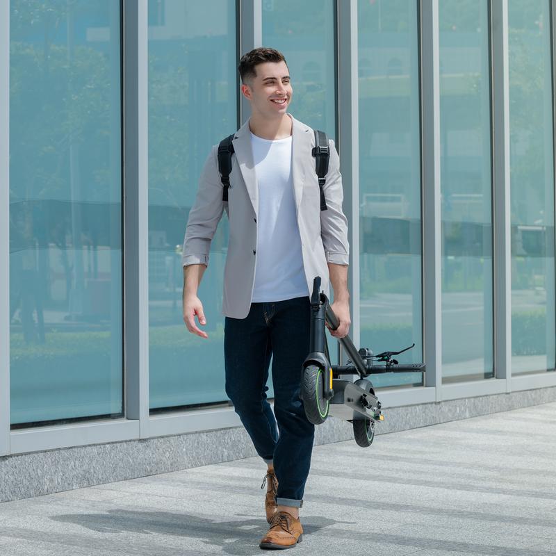 Homme marchant avec la trottinette électrique repliée