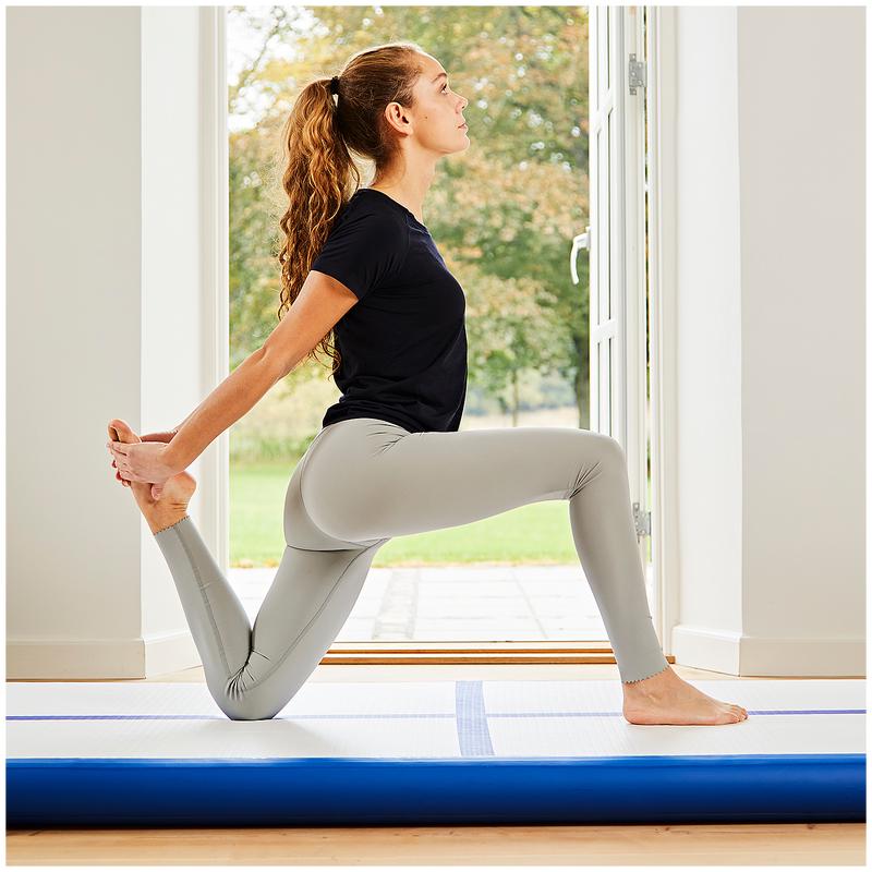 Femme faisant une pose de yoga sur le tapis de gym gonflable 