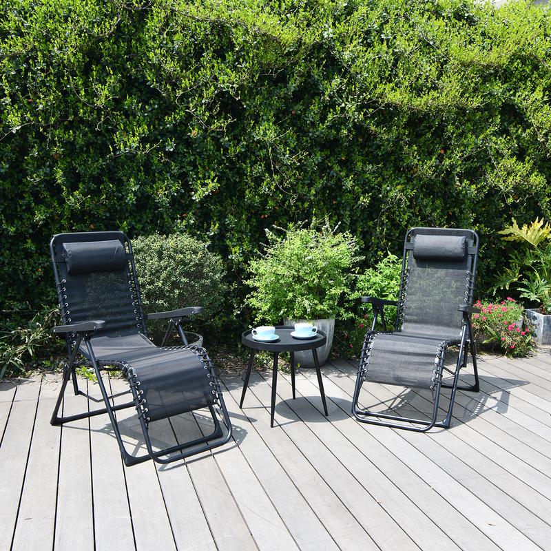 Deux chaises longues réglables installées dehors sur une terrasse avec table d'appoint pour le café
